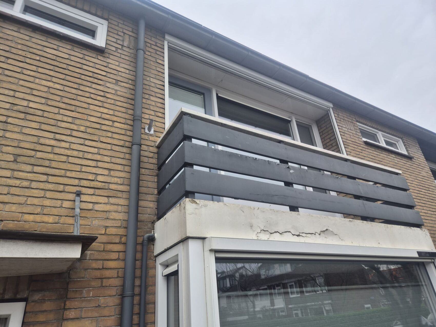 Balkon voor herstel: afbladderend en beschadigd