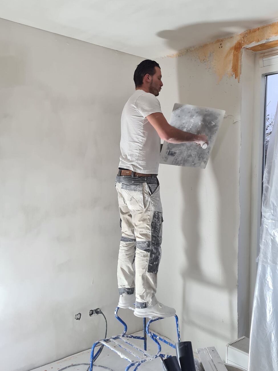 Stucwerk in uitvoering, hoog op de trap